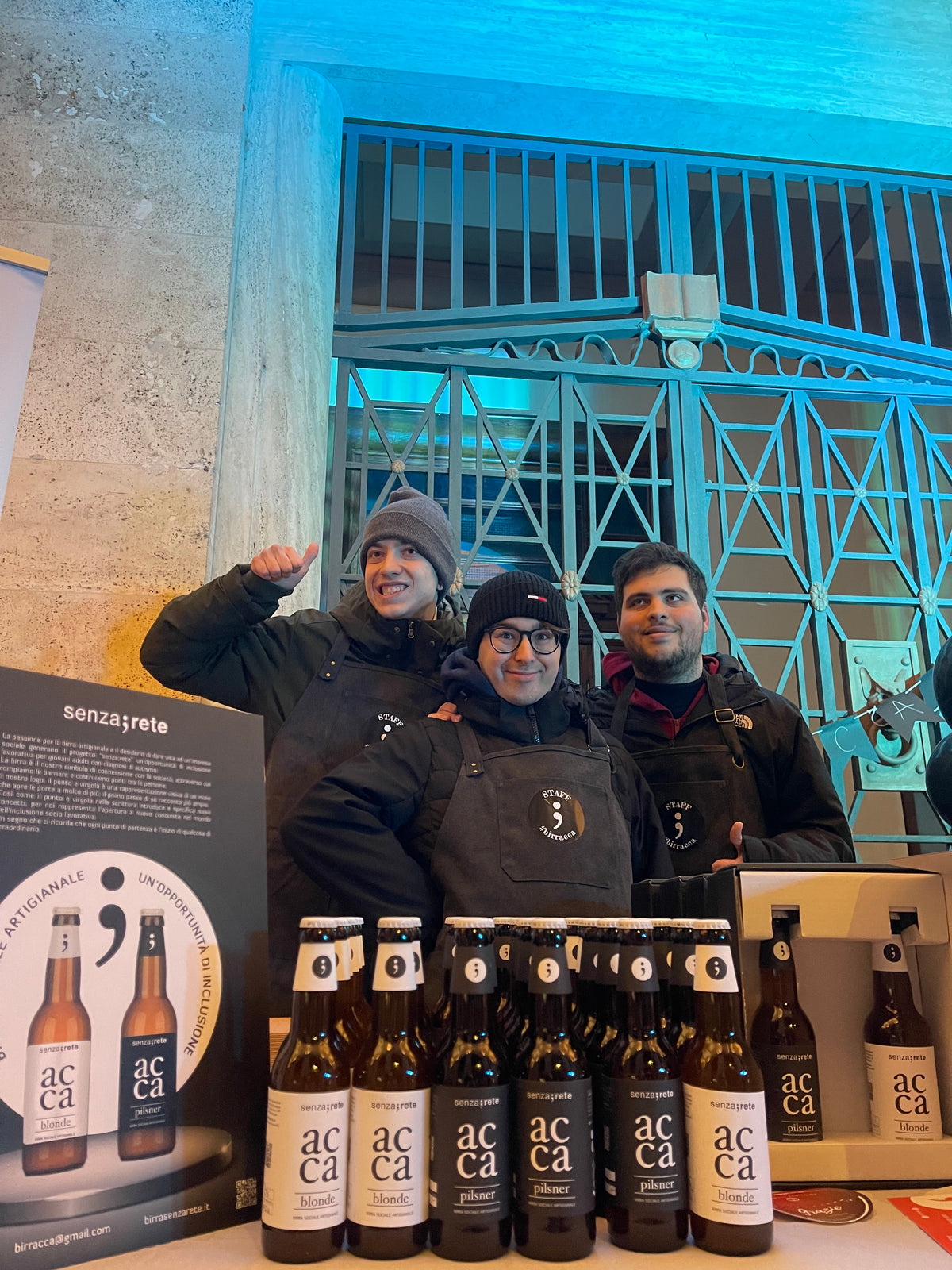 Tre ragazzi di Birracca al banco, con le bottiglie in fila